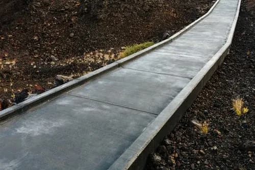 Newly poured concrete sidewalk and curb with a clean broom finish in a New Jersey township
