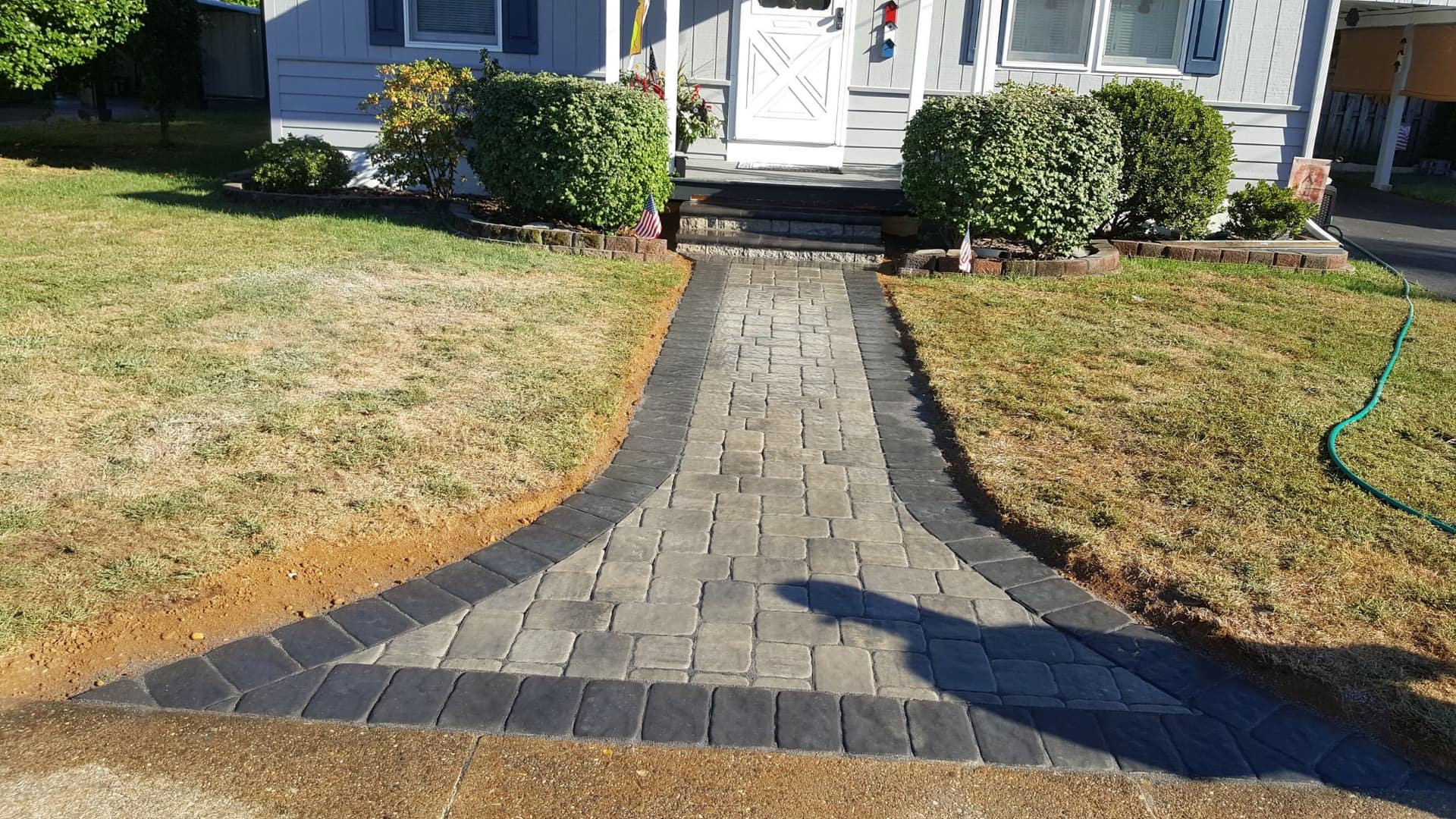 Natural stone paver walkway in a charcoal blend leading to a home's front entry
